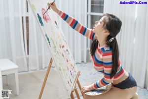 A woman sitting in a bathtub blowing bubbles.