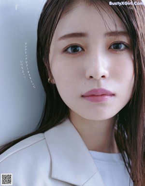 A woman in a white shirt and white pants posing for a magazine.