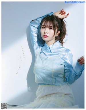 A woman in a white shirt and white pants posing for a magazine.
