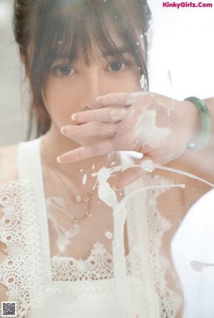 A woman in a white lingerie posing for the camera.