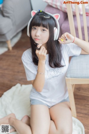 A woman wearing a white shirt and a pair of headphones.