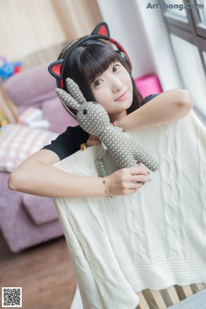 A woman holding a box with a cat ears on it.