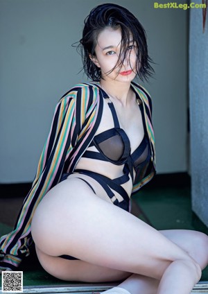 A naked woman laying on top of a bed.