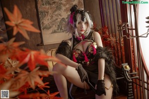 A woman in a black and pink outfit sitting on a table.