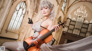 A woman in a white dress playing a violin.