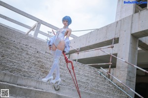 A woman in a white dress sitting on a metal structure.