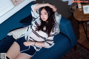 A woman sitting on a bed in a bedroom.
