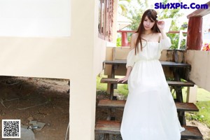 A woman in a yellow bikini standing by a pool.