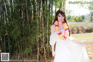 A woman in a white dress standing on a white fence.