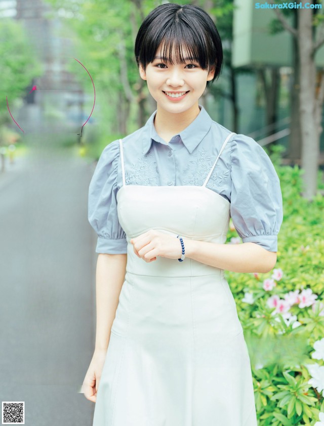 A woman in a white dress posing for a magazine.