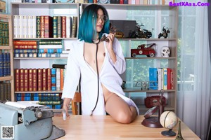 A woman in a white lab coat sitting on a desk.