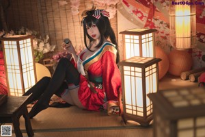 A woman in a red and blue kimono sitting on the floor.