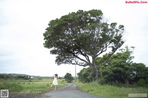 A woman in a white shirt is posing for the camera.