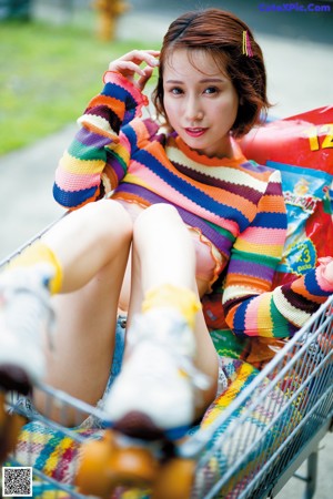 A woman sitting on top of a chair with a skateboard.