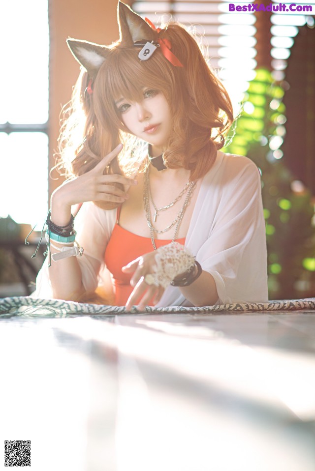 A woman in a cat ears headband sitting at a table.