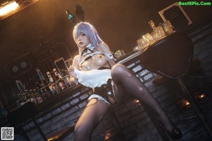 A woman sitting on top of a stool in a bar.