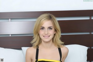 A young woman sitting on top of a bed.