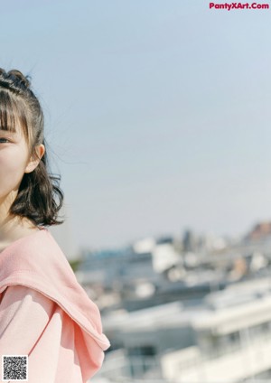 A woman in a pink jacket is posing for a picture.