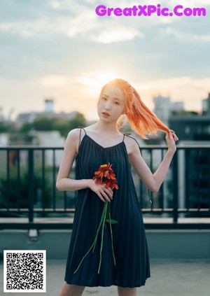 A woman with long red hair sitting on a couch.